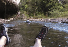 shooting rapids in an innertube approaching the entrance to a ca